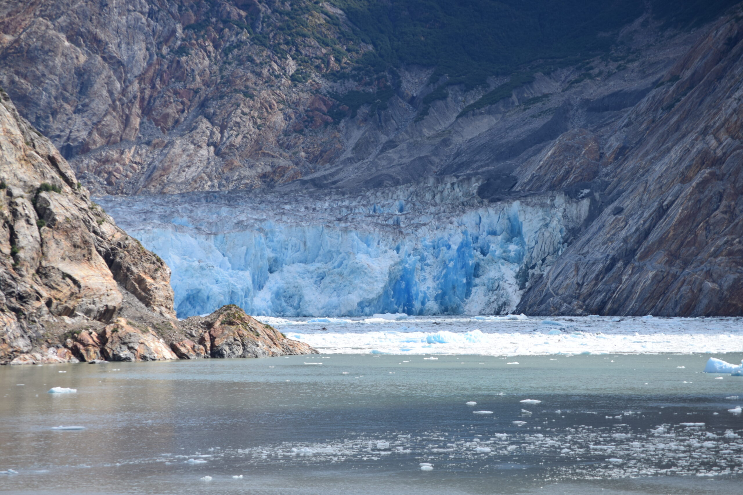 Alaska glacier surrounded by snowcapped mountains viewed from a cruise ship